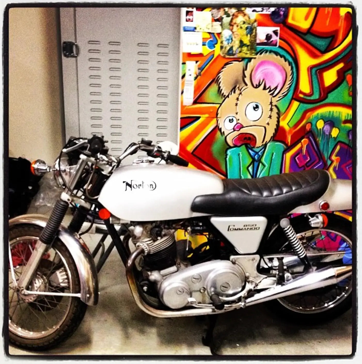 The first Zombie Bear artwork in the warehouse beside a Norton motorcycle